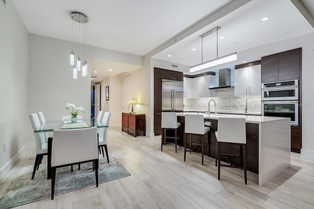 dining space with light wood-type flooring and sink