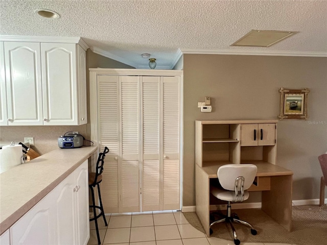 tiled home office with ornamental molding and a textured ceiling