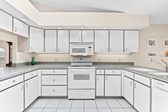 kitchen with white appliances, white cabinetry, light tile floors, and sink