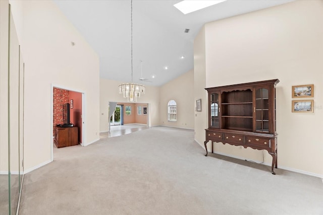 carpeted living room with an inviting chandelier and high vaulted ceiling