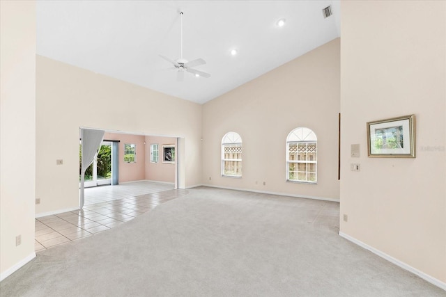 carpeted spare room with ceiling fan and high vaulted ceiling