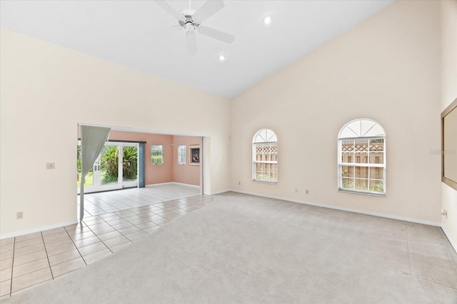 empty room featuring ceiling fan, light colored carpet, and high vaulted ceiling