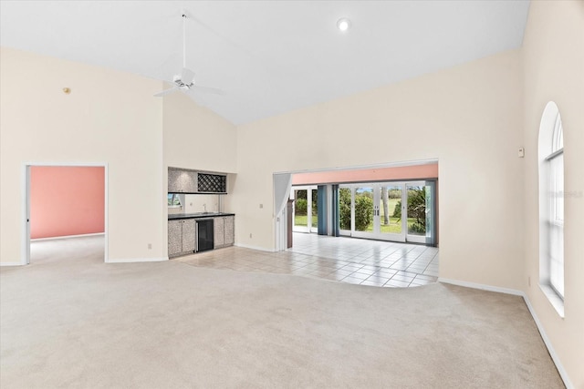 unfurnished living room with ceiling fan, light colored carpet, and high vaulted ceiling