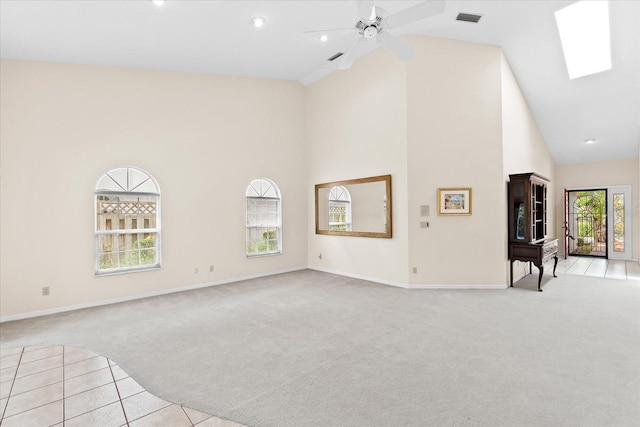 unfurnished living room with light carpet, plenty of natural light, ceiling fan, and high vaulted ceiling