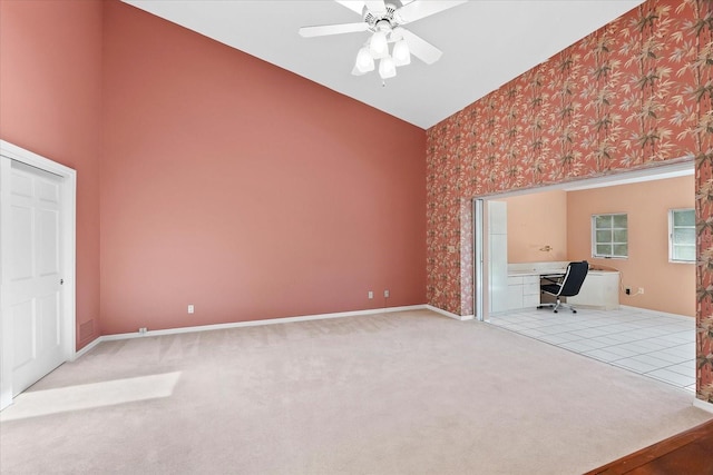 unfurnished living room featuring ceiling fan, light carpet, and high vaulted ceiling