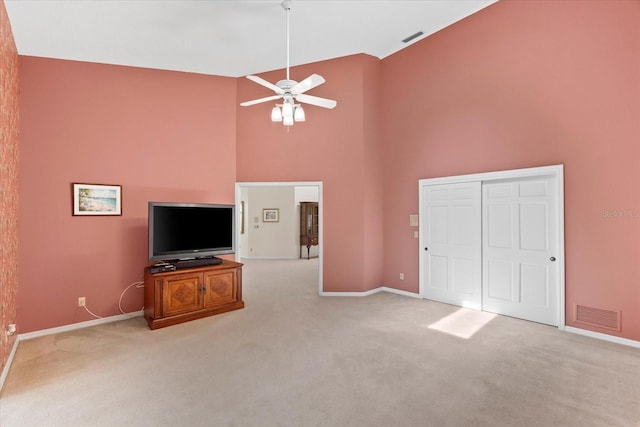 unfurnished living room featuring light colored carpet, ceiling fan, and high vaulted ceiling