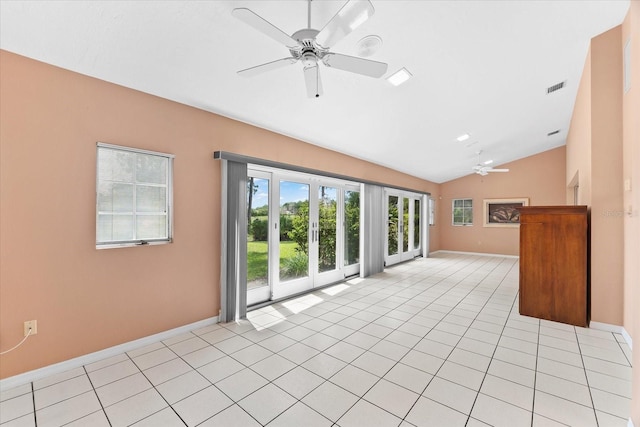 unfurnished living room with ceiling fan, vaulted ceiling, and light tile floors