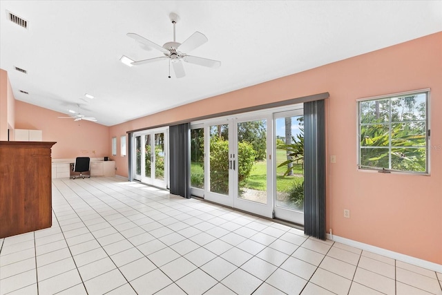 unfurnished living room with ceiling fan, light tile floors, french doors, and vaulted ceiling