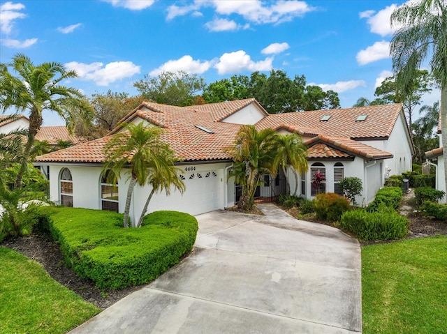 mediterranean / spanish-style home featuring a front lawn and a garage