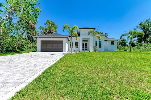 view of front of home with a front yard and a garage