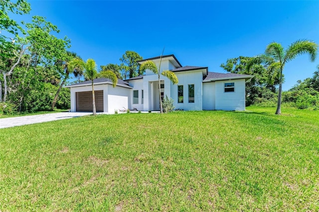 view of front of home with a front yard and a garage