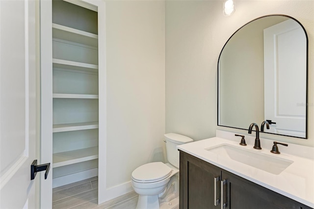 bathroom with tile floors, toilet, and vanity