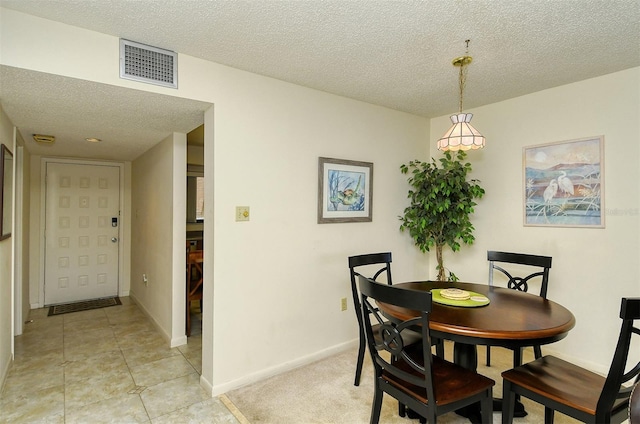 dining area featuring a textured ceiling and light tile flooring