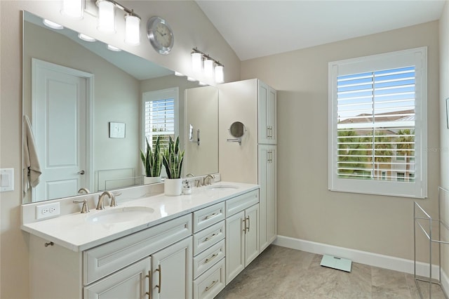 bathroom with a wealth of natural light, tile patterned flooring, vanity, and lofted ceiling