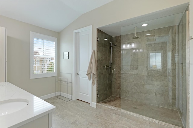 bathroom with vanity, lofted ceiling, and tiled shower