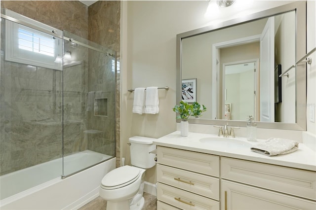 full bathroom with vanity, bath / shower combo with glass door, and toilet