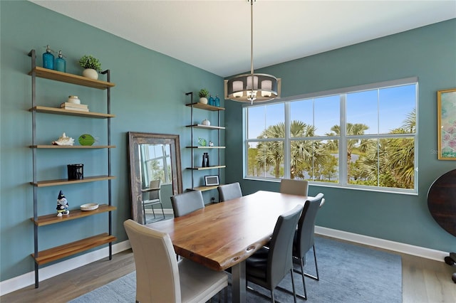 dining area featuring dark wood-type flooring and a chandelier