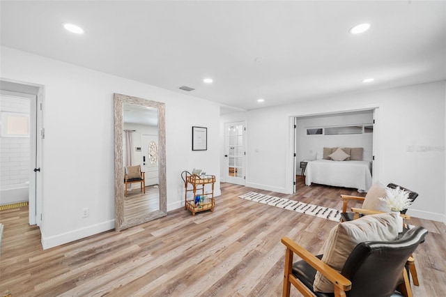 bedroom featuring connected bathroom and light hardwood / wood-style floors