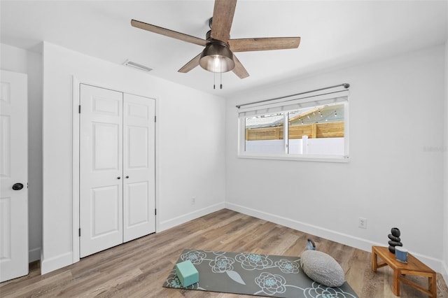 bedroom featuring light wood-type flooring, a closet, and ceiling fan