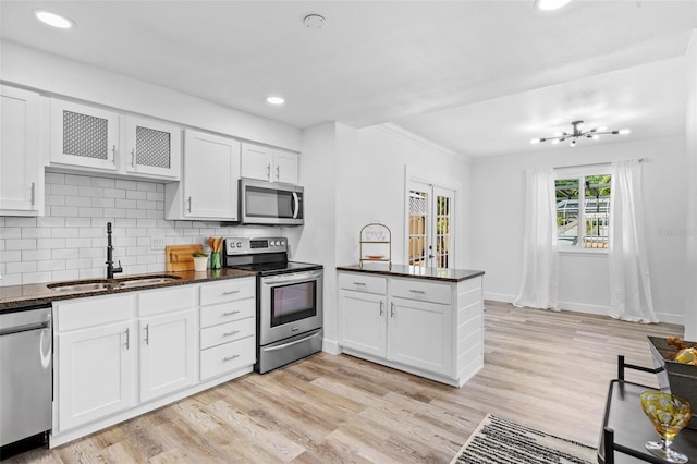 kitchen featuring appliances with stainless steel finishes, kitchen peninsula, sink, and light hardwood / wood-style floors