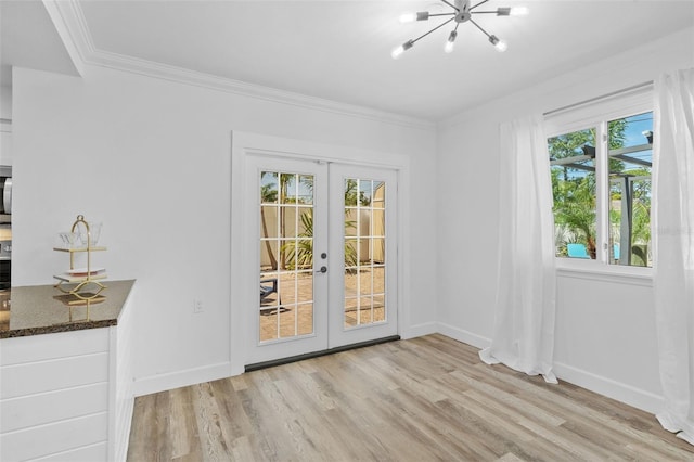 unfurnished dining area with a healthy amount of sunlight, french doors, ornamental molding, and light hardwood / wood-style floors