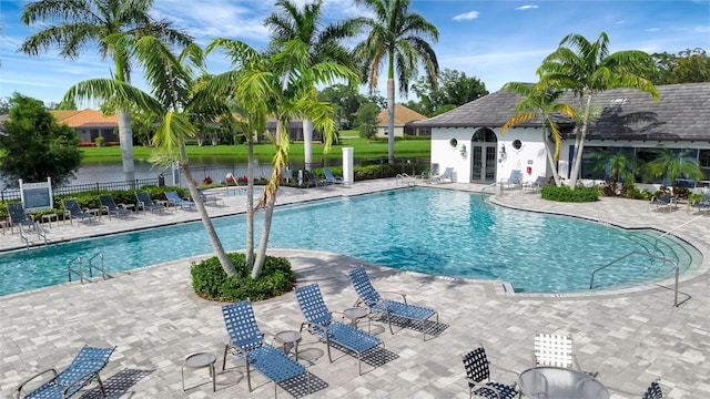 view of swimming pool featuring a patio area and a water view