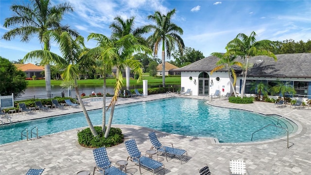 view of pool with a water view and a patio area