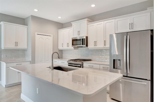 kitchen featuring a center island with sink, sink, white cabinetry, and stainless steel appliances