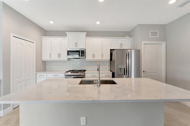 kitchen featuring a center island with sink, white cabinets, sink, and stainless steel appliances