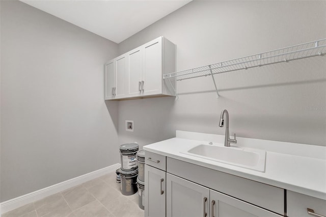 clothes washing area with cabinets, sink, light tile patterned floors, and washer hookup