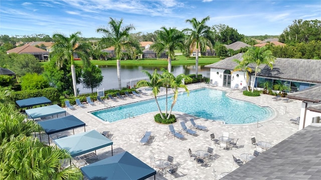 view of pool with a patio and a water view