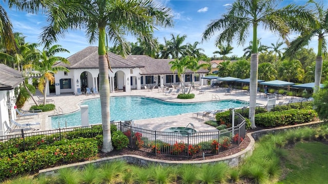 view of swimming pool featuring a patio area and an in ground hot tub