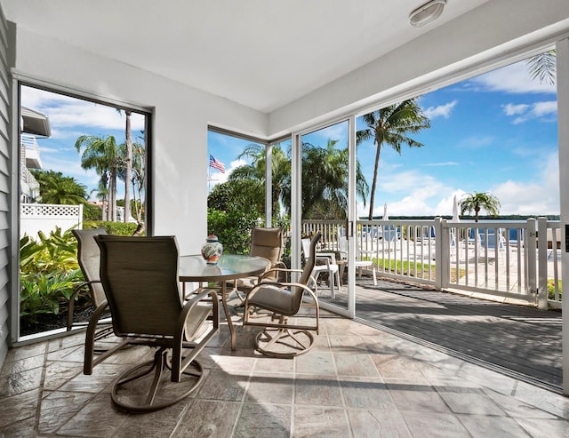 sunroom / solarium featuring a water view