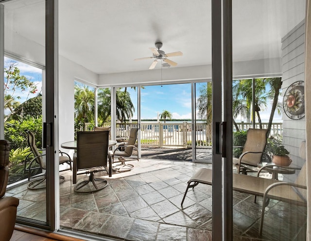 sunroom / solarium featuring ceiling fan