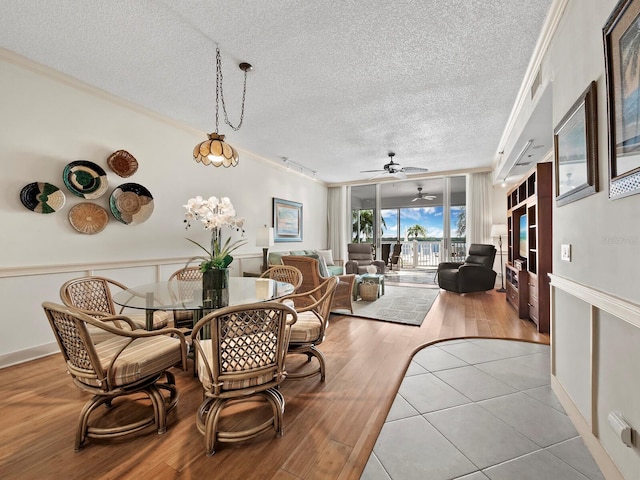 dining room with ceiling fan, light hardwood / wood-style floors, ornamental molding, and a textured ceiling