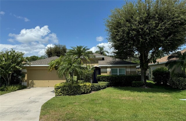 view of front of house with a garage, a front yard, driveway, and stucco siding