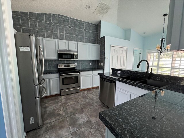 kitchen featuring vaulted ceiling, white cabinetry, a chandelier, and stainless steel appliances