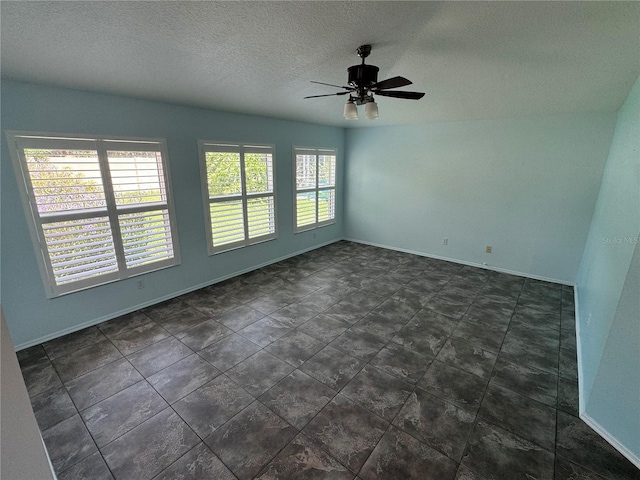 tiled empty room featuring ceiling fan and a textured ceiling