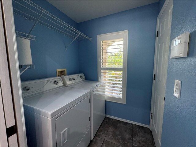 laundry area with dark tile patterned flooring and separate washer and dryer