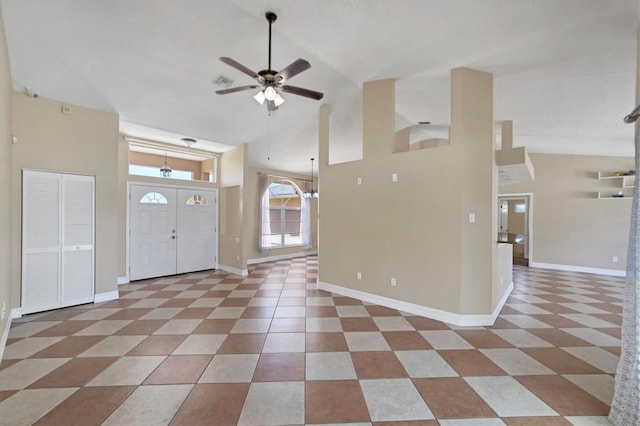 tiled entryway with high vaulted ceiling and ceiling fan with notable chandelier