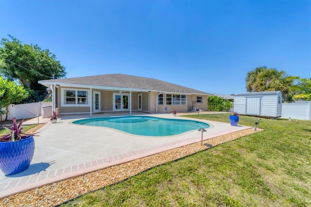 view of swimming pool with a shed, a lawn, and a patio area