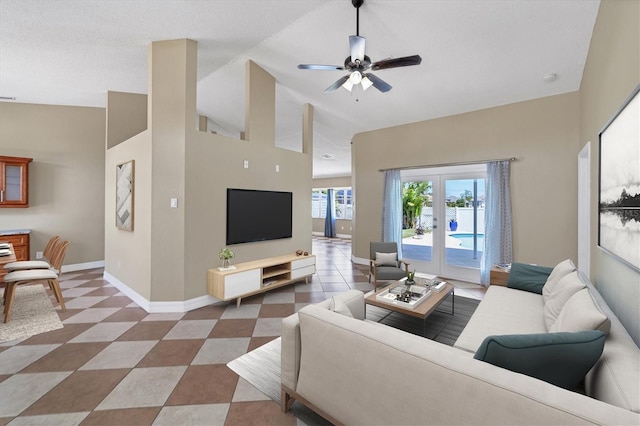 living room featuring high vaulted ceiling, tile flooring, ceiling fan, and french doors