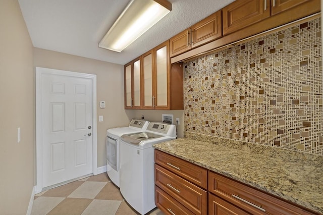 laundry room featuring washer hookup, light tile flooring, cabinets, and separate washer and dryer