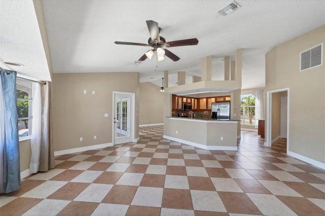 unfurnished living room with light tile flooring, ceiling fan, and a textured ceiling