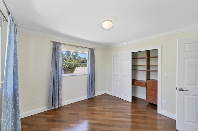 unfurnished bedroom featuring crown molding, a closet, and dark wood-type flooring