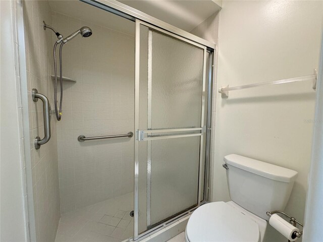 bathroom with toilet and a shower with shower door