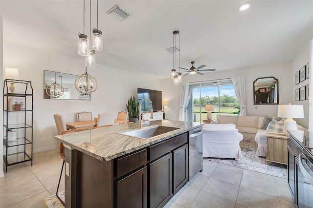 kitchen featuring pendant lighting, stainless steel dishwasher, light stone countertops, a kitchen bar, and ceiling fan with notable chandelier