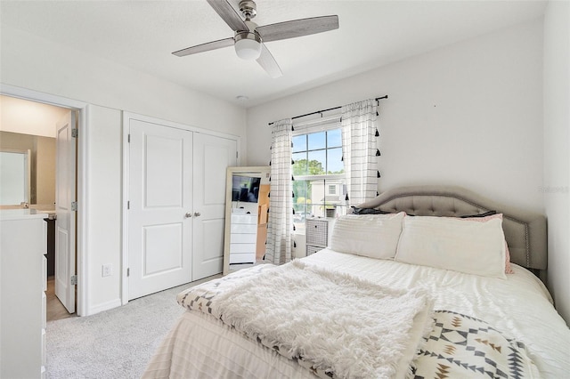 bedroom with a closet, ceiling fan, and light colored carpet