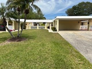 view of front of house featuring a carport and a front yard