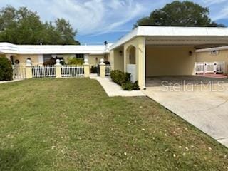 back of property with a carport and a yard